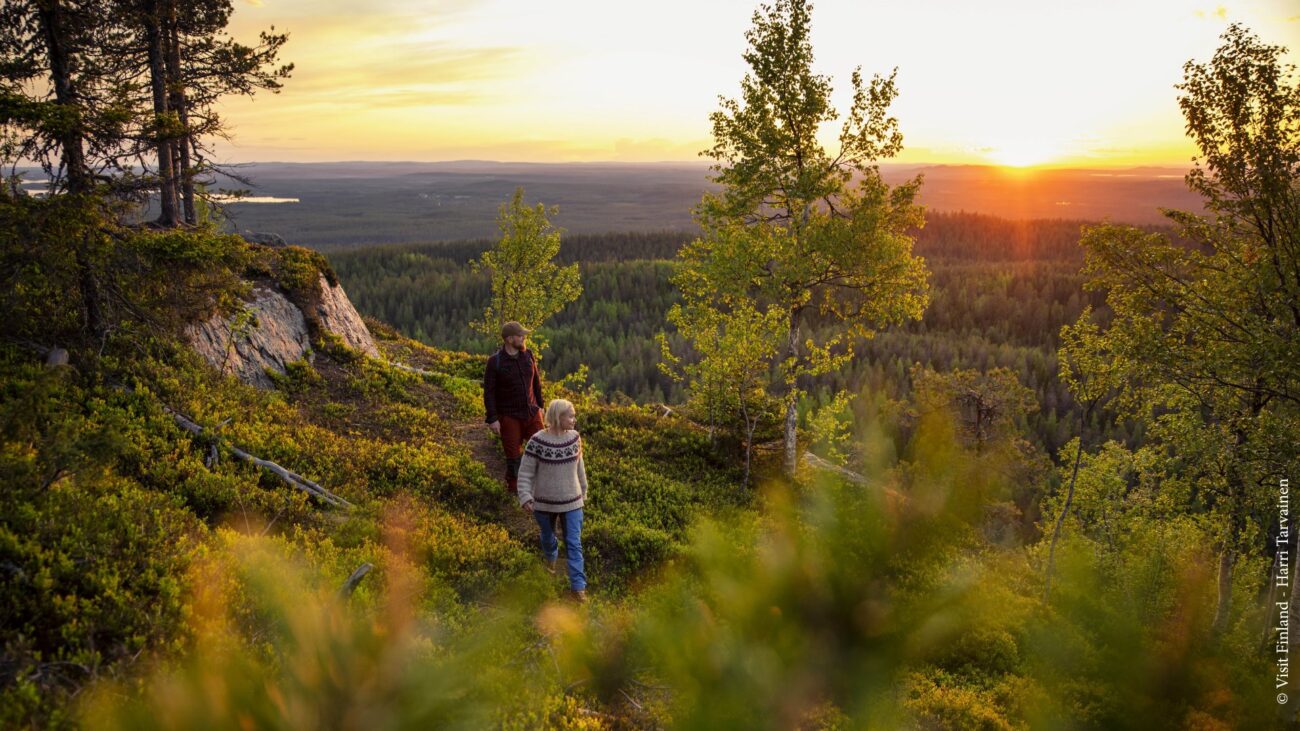 Mann und Frau wandern durch die Landschaft von Ruka-Kuusamo