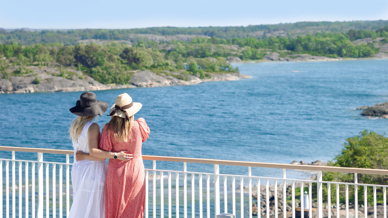 Två tjejer ombord på färjan till Finland, tittar ut över skärgårdshavet