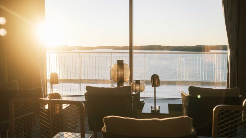 Finnsirius and Finncanopus offer a beautiful place to enjoy sunset: Premium Stellar Lounge. In the picture the sun is setting and bright light is coloring everything with warm tones. The sea is as light blue as the sky.