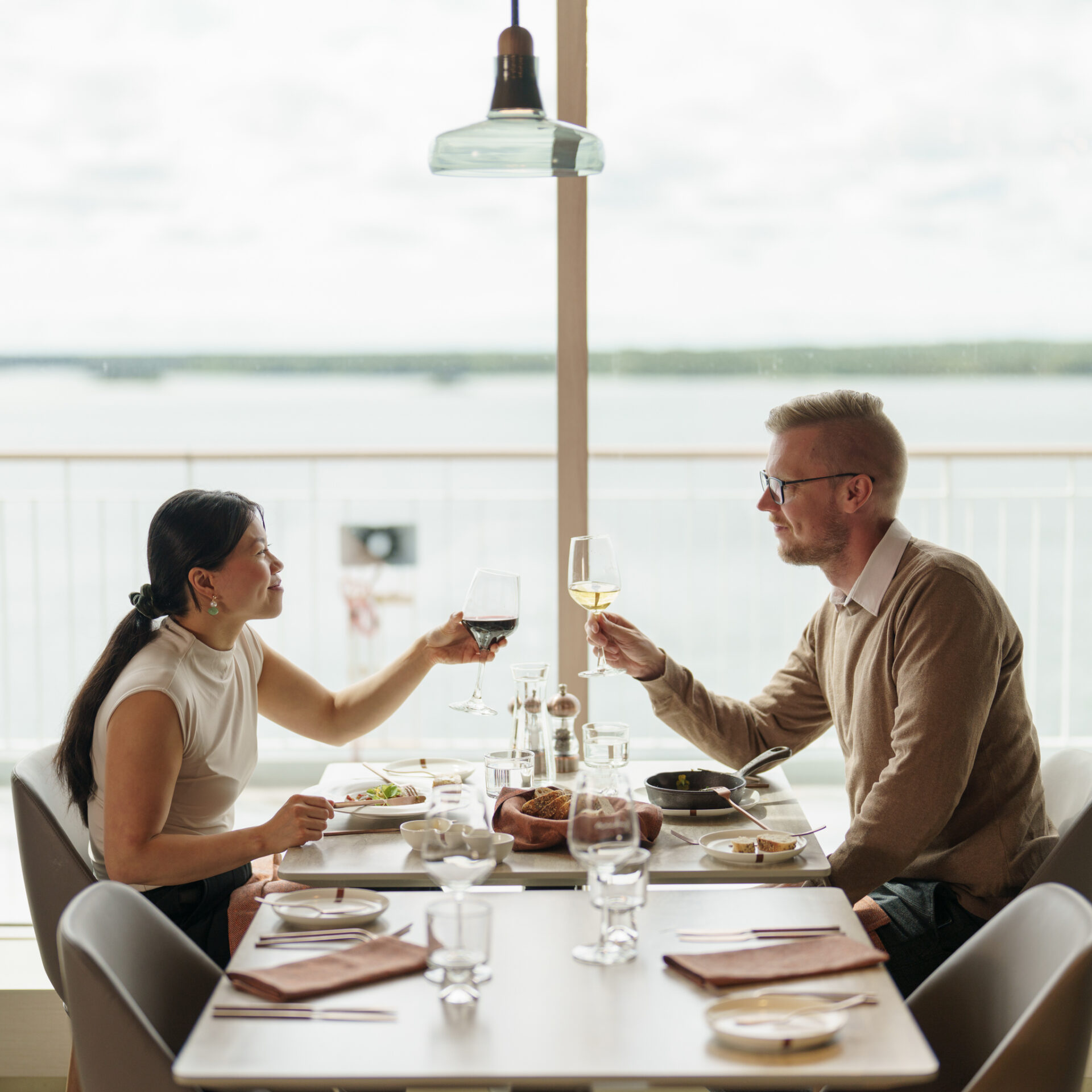 Bild på en kvinna och en man som äter middag i restaurangen Mike's och skålar över bordet.