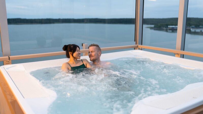 Ett par som sitter i bubbelpoolen på utomhusdäcket som tillhör Höyry Spa