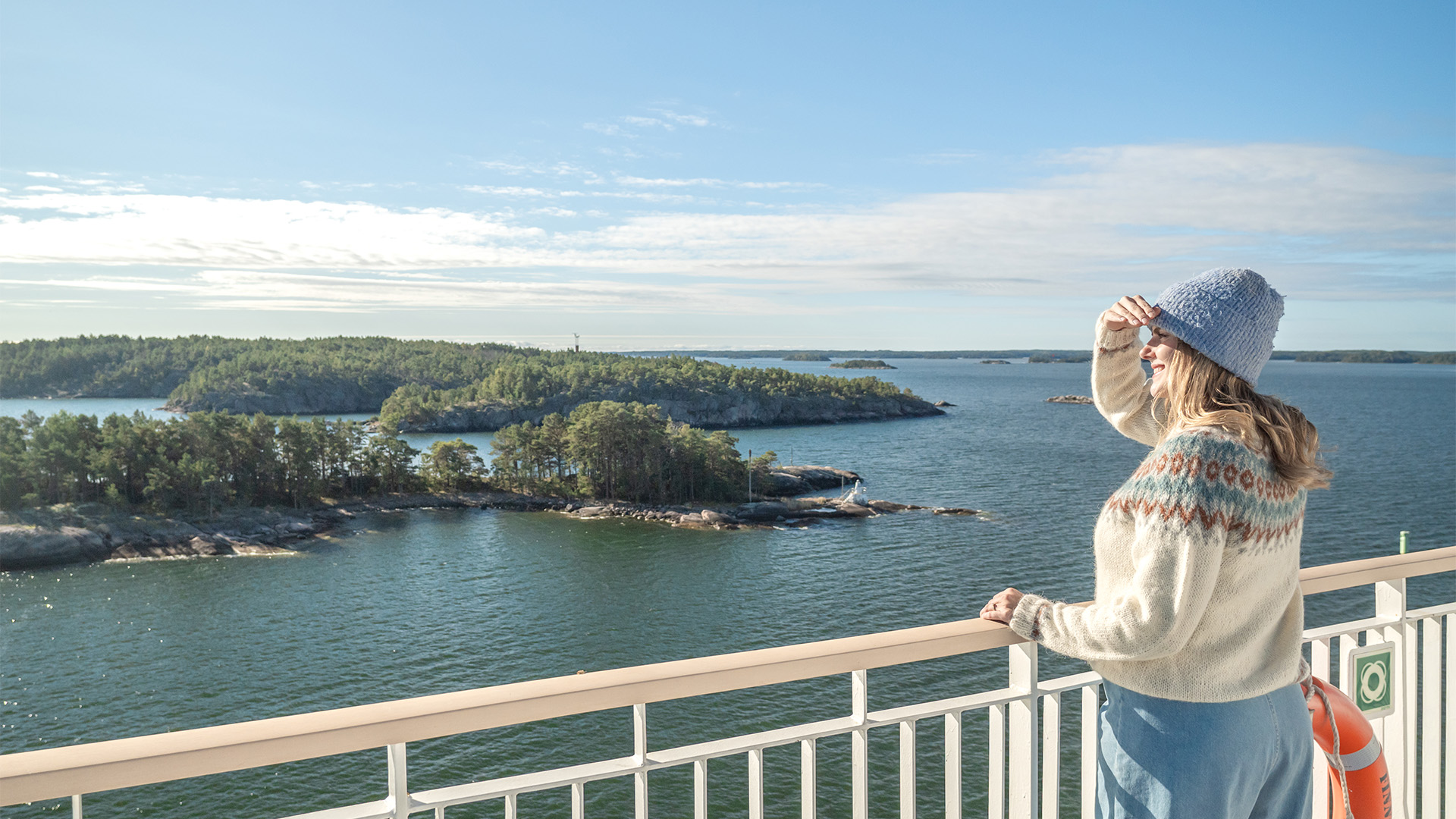 Frau an Deck der Finnlines-Fähre mit Blick auf die Schären vor Helsinki