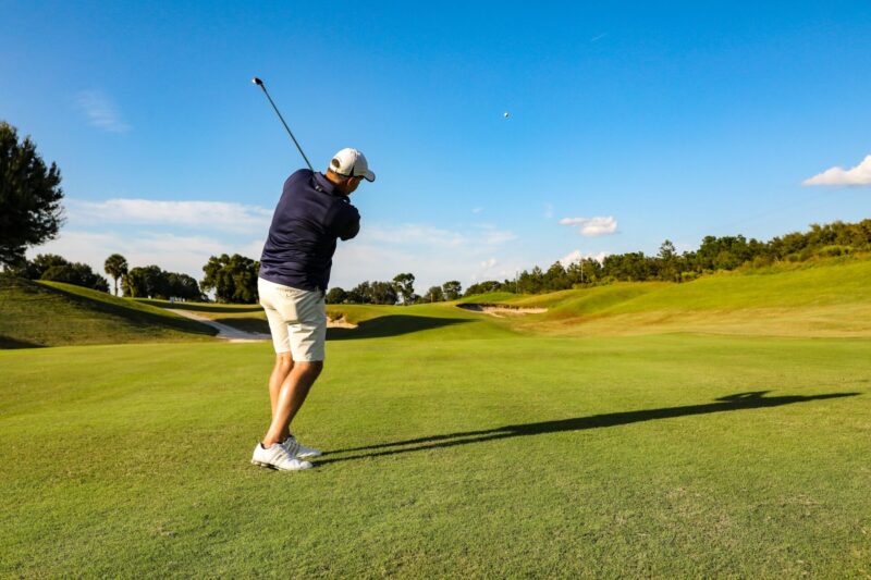 Bild på en golfare som precis har slagit bollen från fairway mot green.