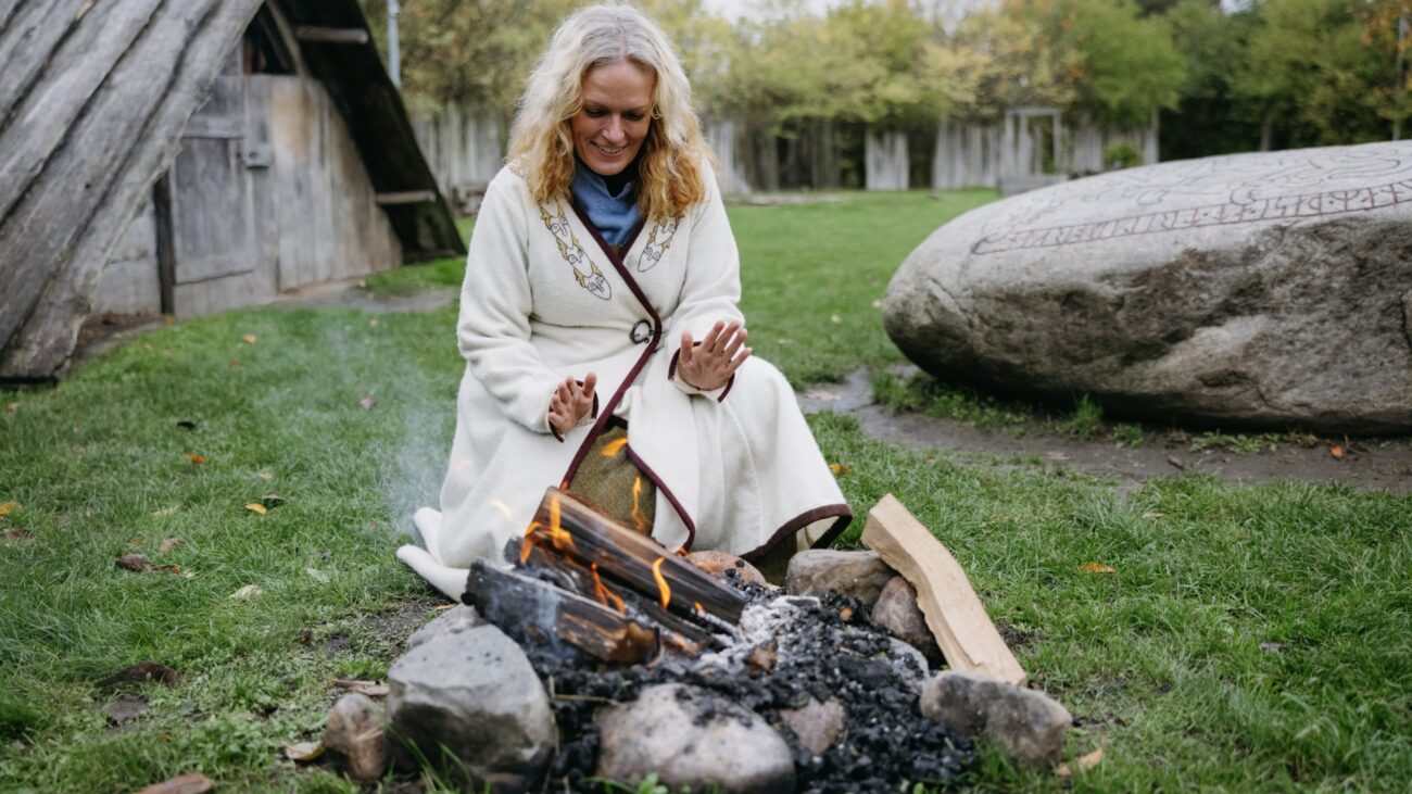 Freichtlichtmuseum der Wikingerburg Trelleborgen mit Frau vor Feuer